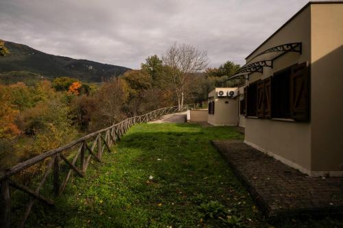 a building with a fence next to a field at Tenuta La Radicale - ZENO 61 intera villa in Subiaco