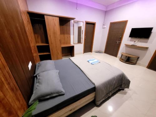 a bedroom with a bed and a tv in it at Areca Homestay in Guwahati
