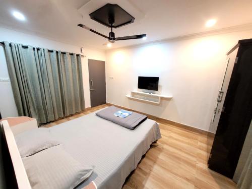 a bedroom with a bed and a flat screen tv at Areca Homestay in Guwahati