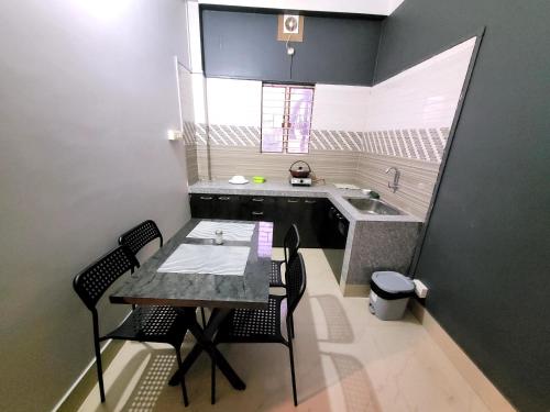 a small kitchen with a table and chairs and a sink at Areca Homestay in Guwahati