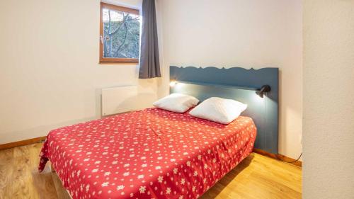 - une chambre avec un lit rouge et 2 oreillers dans l'établissement V du Bachat - Sorbiers F N 11 - 2P6, à Chamrousse