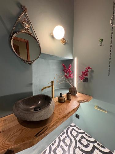 a bathroom with a stone sink on a wooden counter at Το Aρχοντικό των Τσιντζίνων in Polídhroson