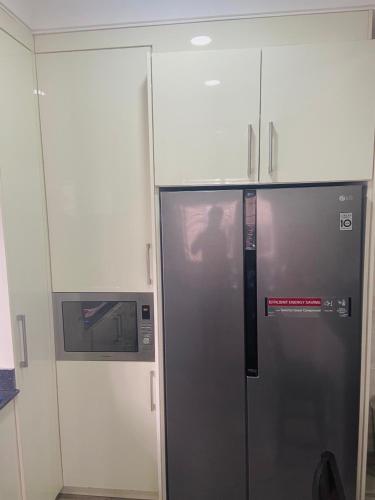 a kitchen with a refrigerator and a microwave at Abuja Horizons Suite in Abuja