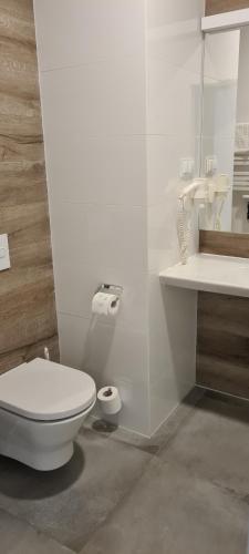 ein weißes Badezimmer mit Toilette und Waschbecken in der Unterkunft Aparthotel Apartamenty Czarna Góra 131 in Heudorf