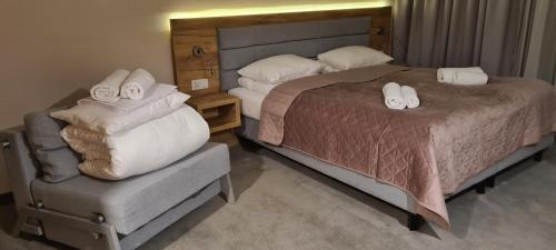 ein Schlafzimmer mit einem Bett und einem Stuhl mit Handtüchern in der Unterkunft Aparthotel Apartamenty Czarna Góra 131 in Heudorf