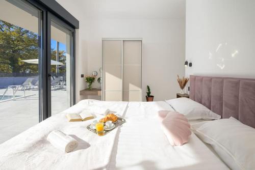 - un lit blanc avec un plateau de nourriture dans l'établissement Villa Lamia by IstriaLux, à Burići
