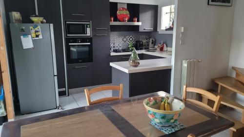 - une cuisine avec une table et un bol de bananes dans l'établissement Chambre Uzès, à Uzès