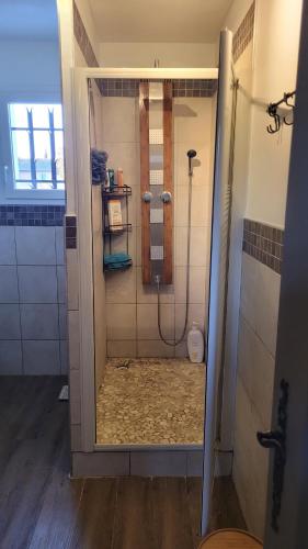 une douche avec une porte vitrée dans une salle de bain dans l'établissement Chambre Uzès, à Uzès
