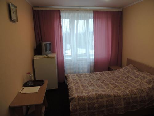 a hotel room with a bed and a television at Готельно-ресторанний комплекс Поділля in Bershadʼ