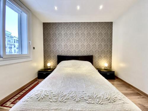 une chambre avec un grand lit avec deux tables de nuit dans l'établissement HENRY IV 2 pieces MES1112, à Cannes