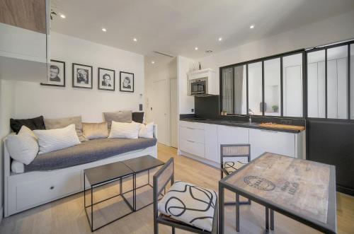 un salon avec un canapé et une cuisine dans l'établissement Le Nico - Elégant - Centre - VCA, à Cannes