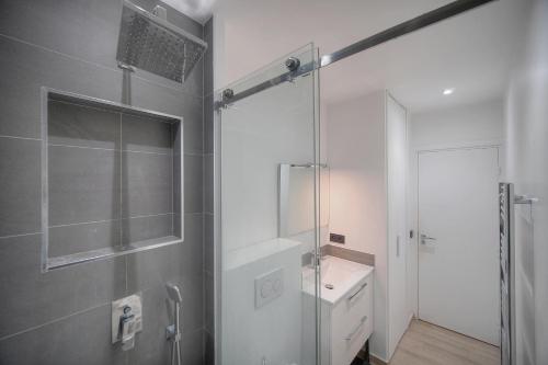 une salle de bain avec une douche en verre et un lavabo dans l'établissement Le Nico - Elégant - Centre - VCA, à Cannes