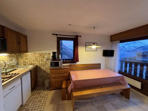 - une cuisine avec un lit, un évier et une fenêtre dans l'établissement Appartement confort 3 pièces cabine skis aux pieds, balcon, 6 personnes - Auris en Oisans - FR-1-297-27, à Auris