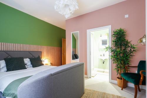 a bedroom with a bed and a green and pink wall at Leah Suite by Koya Homes - 2 Bed, 2 Bath, Pool Table, Sea View, Free Parking in Barry