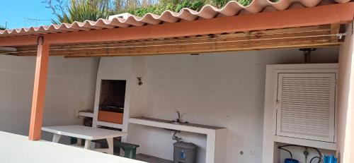 a patio with a wooden pergola and a bench at Cantinho da Ribeira in Castelo Branco
