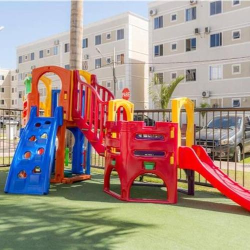 a playground with a slide in front of a building at Aconchego Apartamento in Várzea Grande