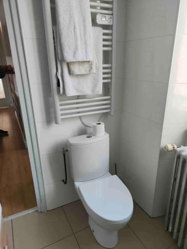 La salle de bains est pourvue de toilettes blanches et de serviettes. dans l'établissement Appartement chaleureux à Néris-les-Bains - 57 m² avec terrasse, à Néris-les-Bains
