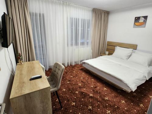 a bedroom with a bed and a desk and a television at Holiday Houses in Sinaia