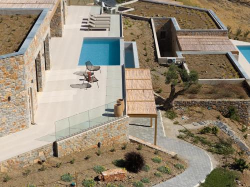 an external view of a house with a swimming pool at VK Villas - Votsalo & Kyma Villas, By ThinkVilla in Léntas