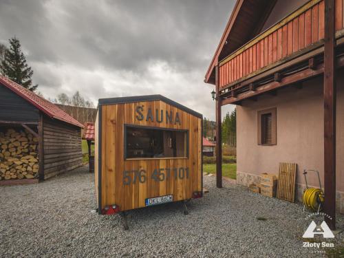 a wooden tiny house sitting next to a building at Złoty Sen Agroturystyka in Stronie Śląskie