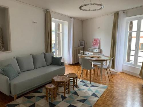 ネリ・レ・バンにあるAppartement confortable à Néris-les-Bains avec parking gratuitのソファとテーブルのあるリビングルーム