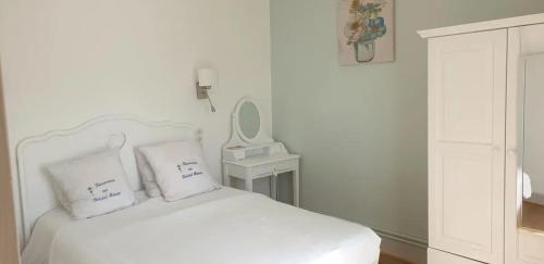 ネリ・レ・バンにあるAppartement confortable à Néris-les-Bains avec parking gratuitの白いベッドルーム(鏡付き白いベッド1台付)