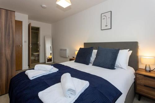 a bedroom with a large bed with towels on it at Media City Salford Quays Flat by City SuperHost in Manchester