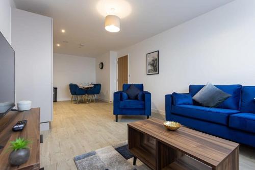 a living room with blue couches and a table at Media City Salford Quays Flat by City SuperHost in Manchester
