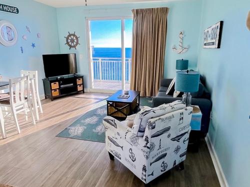 a living room with a couch and a chair and a television at Sterling Reef 1603 Waterfront in Panama City Beach