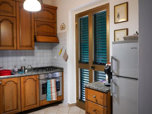 a kitchen with wooden cabinets and a white refrigerator at Casa Natalina in Montecatini Terme