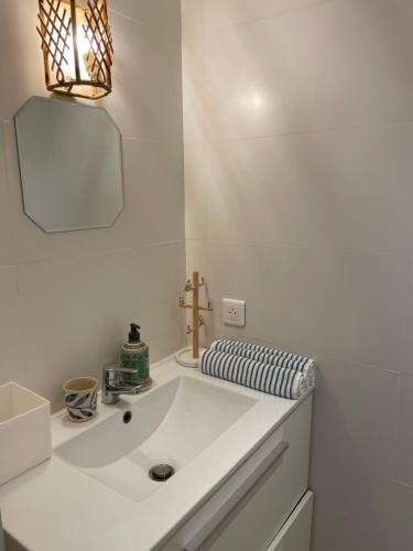 une salle de bain blanche avec un lavabo et un miroir dans l'établissement Les Terrasses D'Aix, à Aix-en-Provence