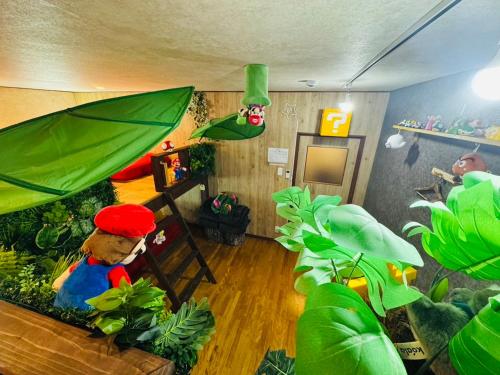 een kamer met planten en een speelgoedmannetje met een paraplu bij Hotel Emiru 敷地内駐車場2台 in Osaka