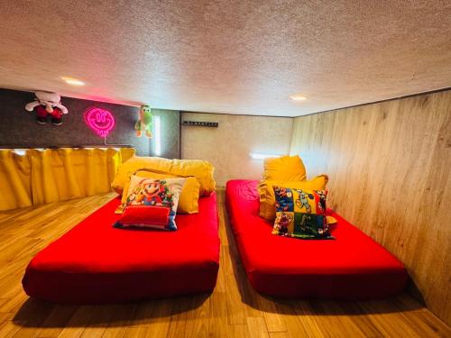 twee rode bedden op de vloer in een kamer bij Hotel Emiru 敷地内駐車場2台 in Osaka