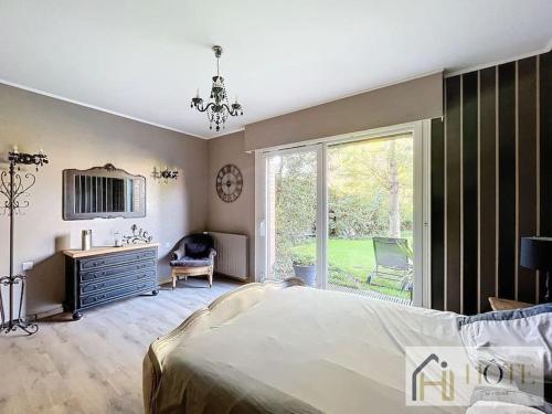 una camera da letto con un letto, una scrivania e una finestra di Le Domaine Sérénité - Maison de caractère a Dunkerque