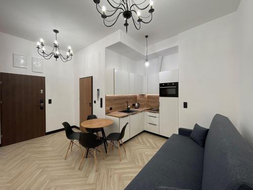 a living room with a couch and a table and a kitchen at Pod Błękitnymi Podkowami in Wrocław