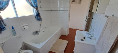 Un baño con bañera, inodoro y lavabo. en Unit 75 Hermanus Beach Club, en Hermanus