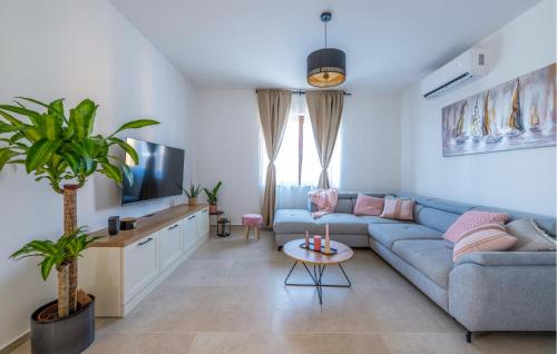 a living room with a blue couch and a tv at Lovely Home In Gajana in Gajana