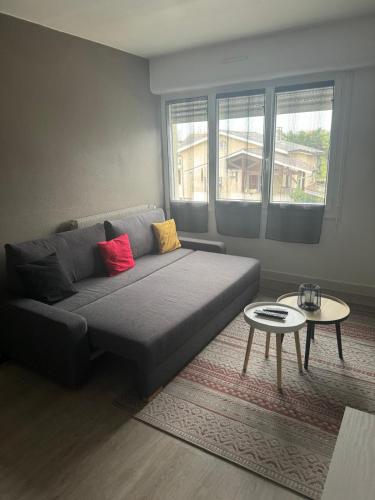 a living room with a couch and a table at Talence - Studio 25 m2 dans résidence avec parking privé à 10 mn de Bordeaux en Tram in Talence