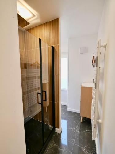 a shower with a glass door in a bathroom at D-Day Suites in Carentan