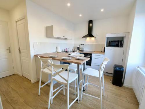 a kitchen with a table and chairs in a room at D-Day Suites in Carentan