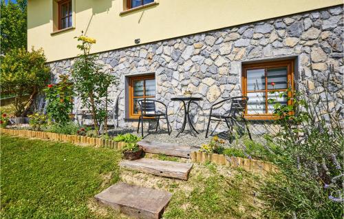 a stone house with a table and chairs in a yard at 2 Bedroom Nice Home In Donja Stubica in Donja Stubica