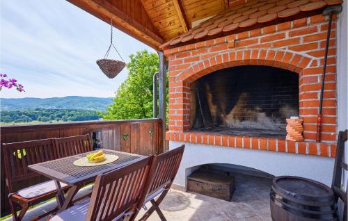 a table and chairs on a patio with a brick fireplace at 2 Bedroom Nice Home In Donja Stubica in Donja Stubica