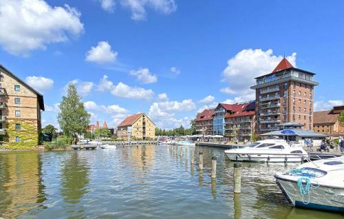 a river with boats docked in a city with buildings at Ferienwohnung Neustrelitz in Neustrelitz