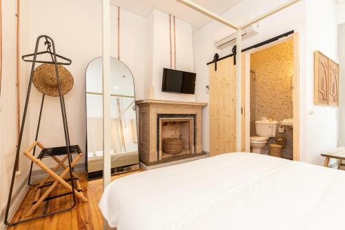 a bedroom with a bed and a fireplace at Amália Boutique Suites & Studios - by @ rita´s place in Faro