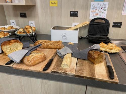 a counter with lots of different types of bread at Ibis Styles Crolles Grenoble A41 in Crolles