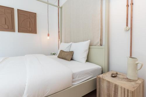 a bedroom with a white bed and a wooden table at Amália Boutique Suites & Studios - by @ rita´s place in Faro