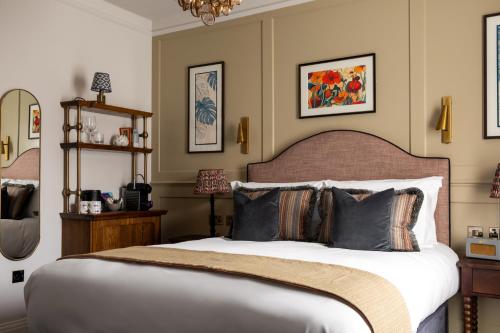 a bedroom with a large bed with pillows at Coach & Horses Hotel in London