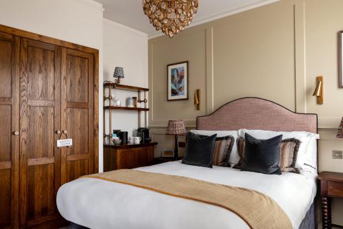a bedroom with a large bed and a chandelier at Coach & Horses Hotel in London