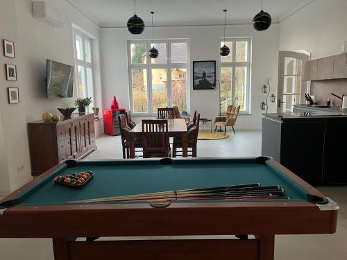 a living room with a pool table and a kitchen at Ferienwohnung Villa Bismarck mit Sauna und Whirlpool in Görlitz