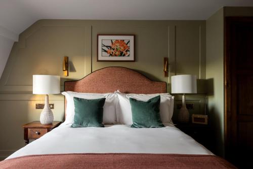 a bedroom with a bed with pillows and two lamps at Coach & Horses Hotel in London